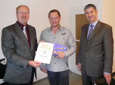 DA-Vorsitzender Walter Werner (l.) und Finanzvorstand Johannes Harzheim (r.) übergeben Unternehmer Christian Laabs die Ehrenurkunde des Verbands.