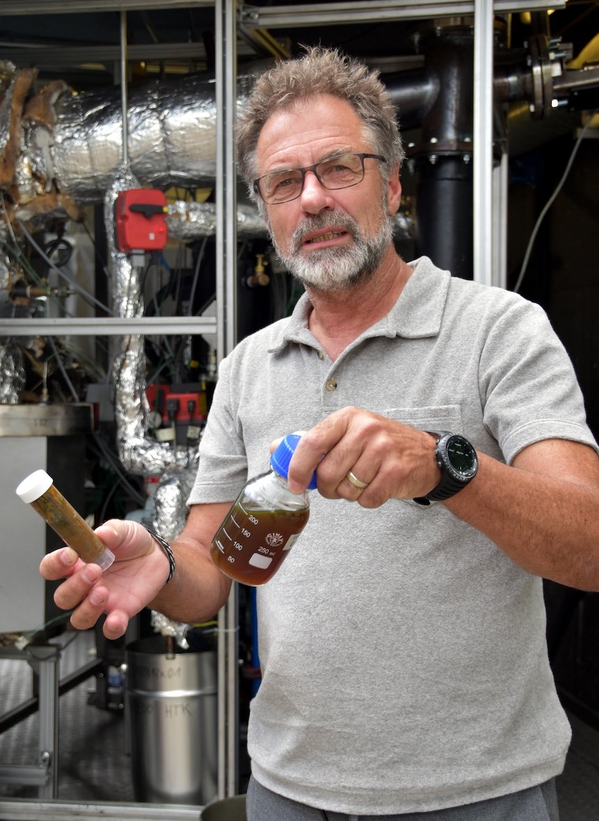 OEOO-Umweltingenieur Erich Groever mit zwei Proben des aus Plastikmüll aus dem Meer gewonnenen Öls (Foto: One Earth – One Ocean e. V. (OEOO))