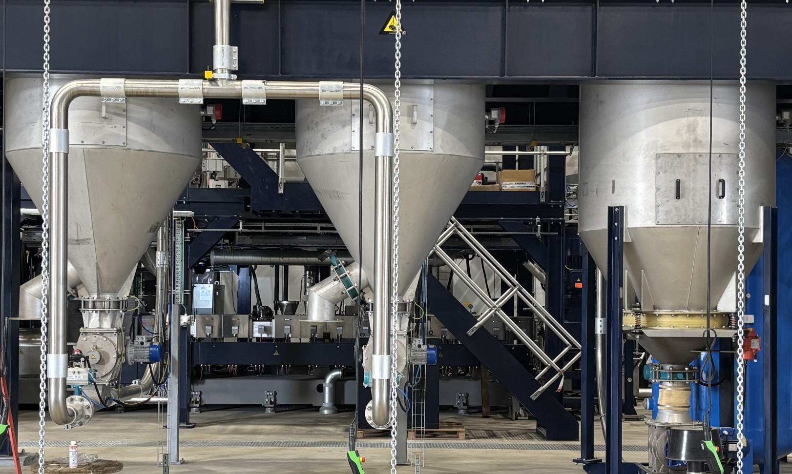 Blick in die neue Borealis-Compounding-Anlage in Beringen mit mehreren großen Edelstahltrichtern und Fördertechnik.
