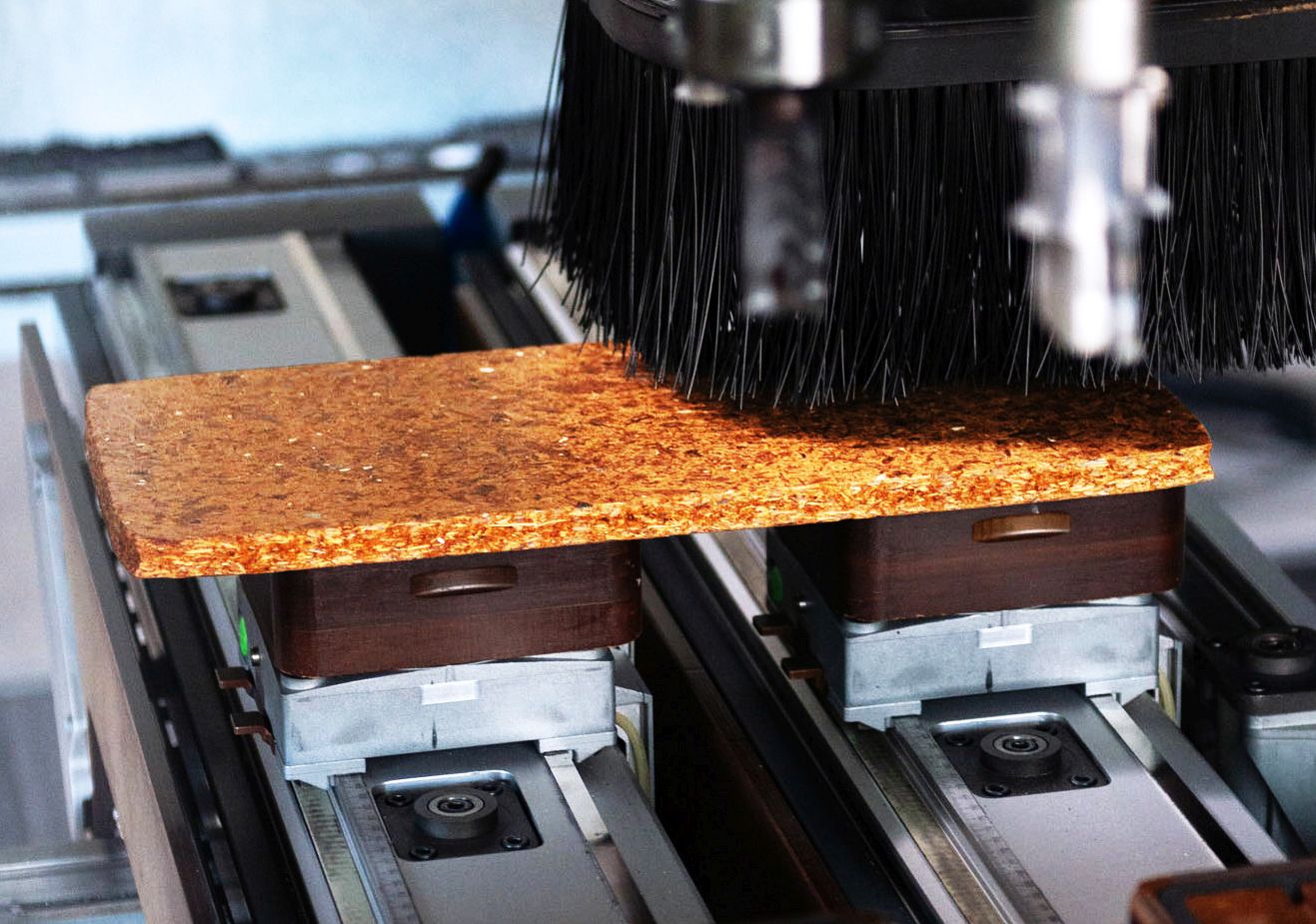 Eine Maschine verarbeitet recyceltes Holz zu einer neuen Spanplatte im Rahmen eines Forschungsprojekts.