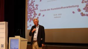 Felix Loose steht am Rednerpult und eröffnet die TecPart-Jahrestagung 2025 in Heilbronn vor zahlreichen Teilnehmenden.
