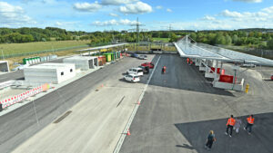 Luftaufnahme des neuen Wertstoffzentrums in Gilching mit Zufahrtsbereich, Containern, Photovoltaik-Dach und Besuchern auf dem Gelände.